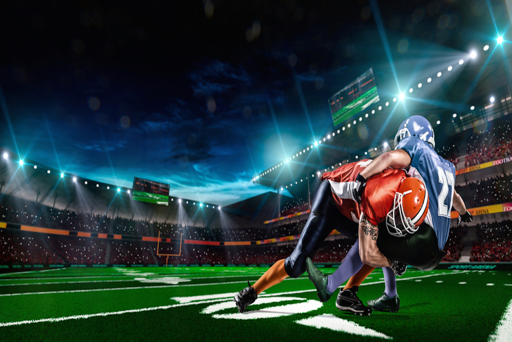 Two football players tackling on the field.