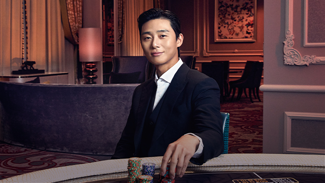 Man in suit sitting at poker table.